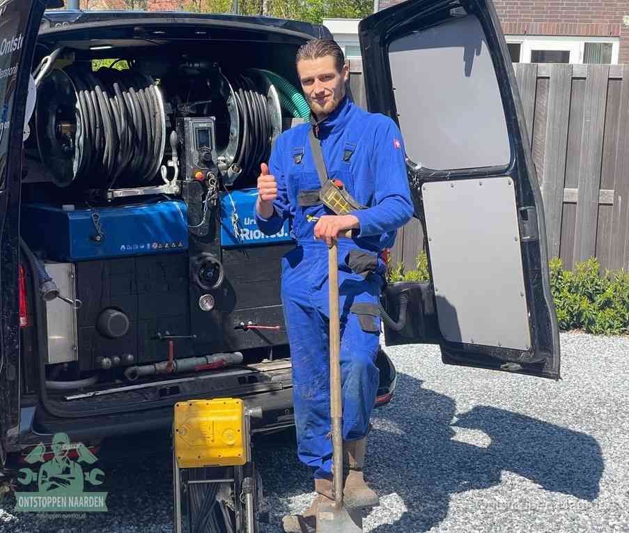 Een tevreden monteur met opgestoken duim naast de bestelbus, slim en snel ingrijpen bespaart geld bij een verstopping in Naarden