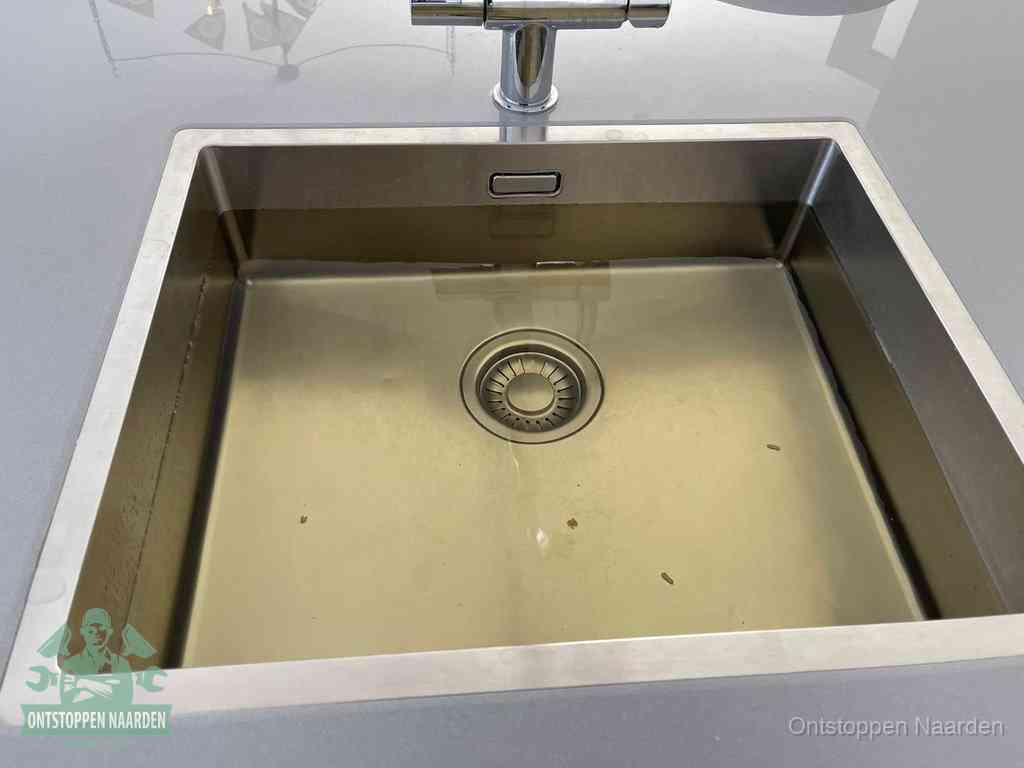 Een RVS spoelbak met stilstaand water dat niet wegloopt, een van de eerste signalen van een beginnende verstopping in Naarden
