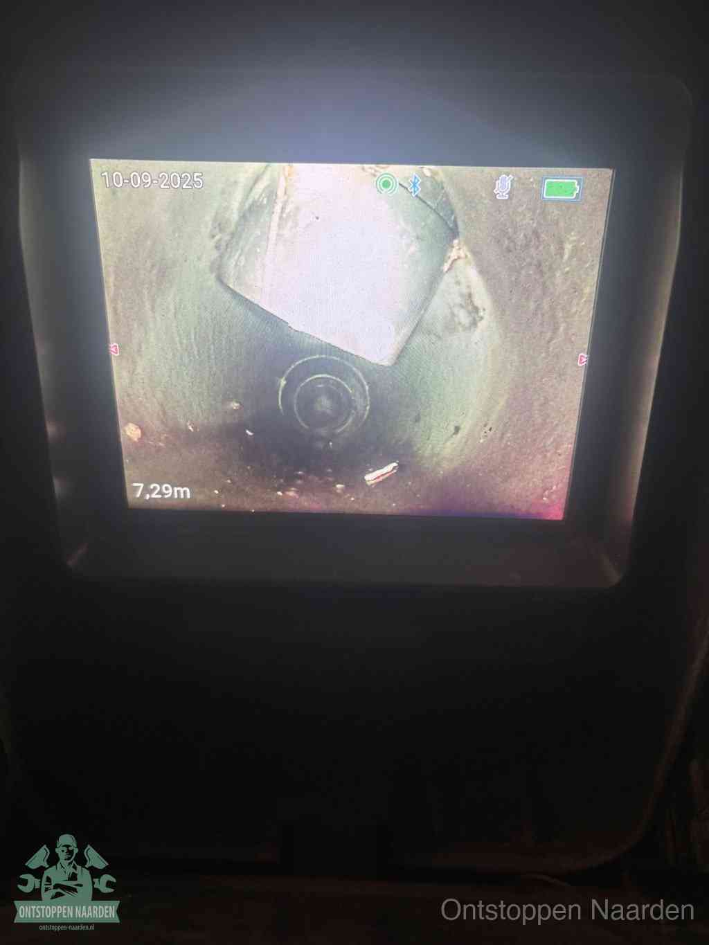 Het scherm van een rioolinspectiecamera toont de binnenkant van de leiding, eerst vaststellen waar de verstopping zit in Naarden