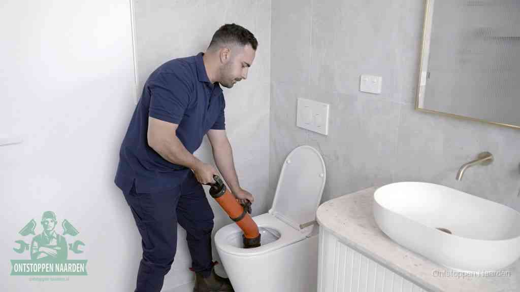 Een wc wordt met een handmatige ontstopper losgepompt, een verstopt toilet zelf ontstoppen met huismiddelen in Naarden